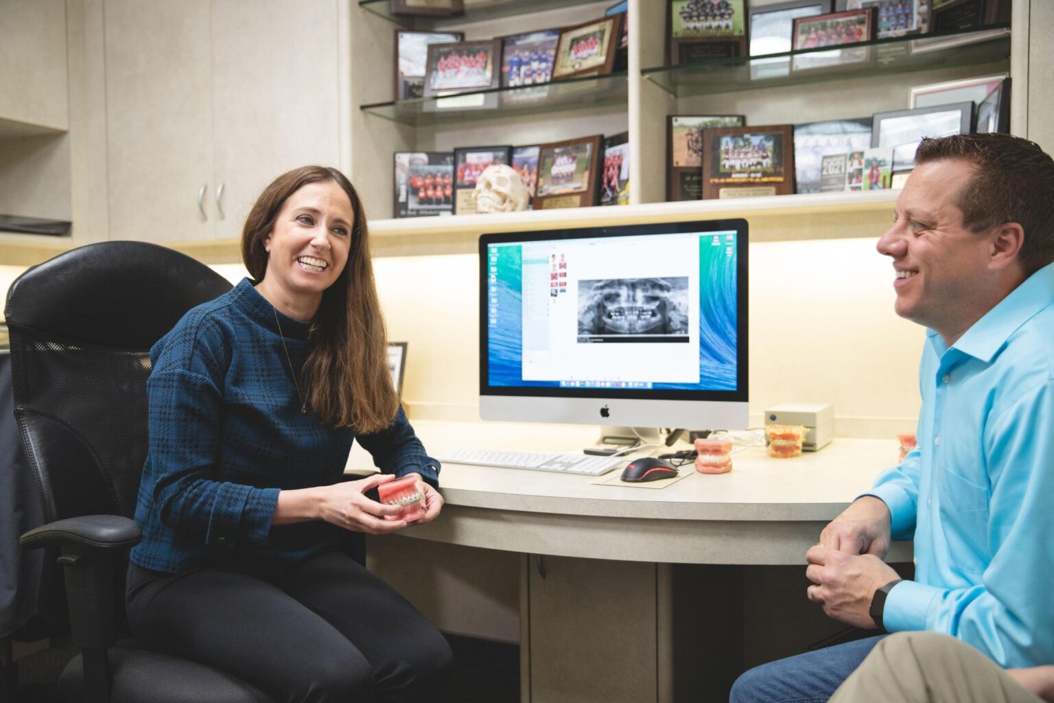 Dr. Johnston smiling with patient during orthodontic consultation at Johnston Orthodontics in Baytown, discussing clear aligners and treatment options.